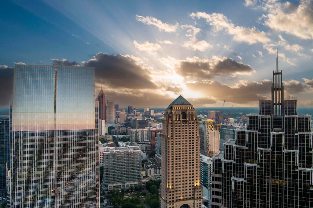 aerial shot of Truist Plaza, Symphony Tower, office buildings and apartments in the city skyline, tower cranes, blue sky and clouds at sunset in Atlanta Georgia USA