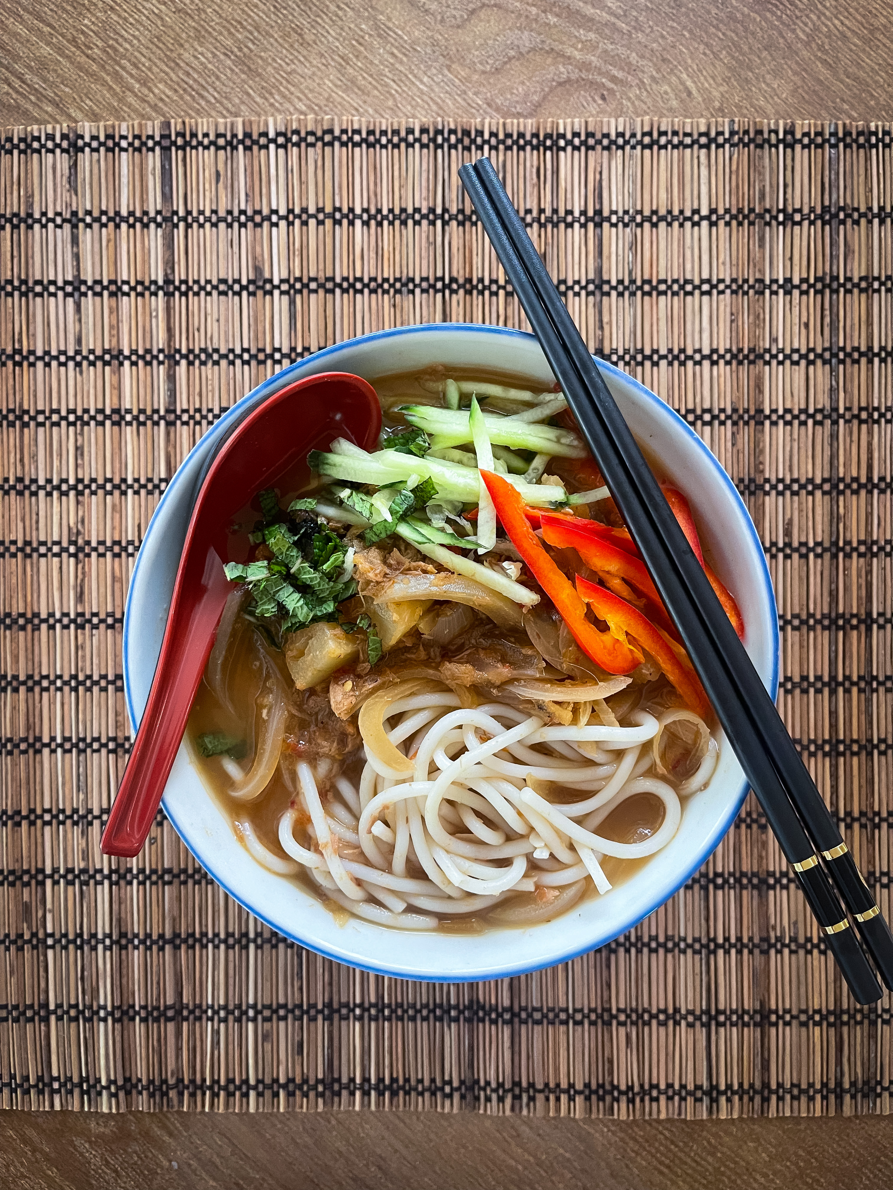 Penang assam laksa, a Malaysian noodle soup characterized by a tangy and umami mackerel fish-based broth in which thick chewy rice noodles found at Penang Malaysian Cuisine in Kennesaw Georgia.