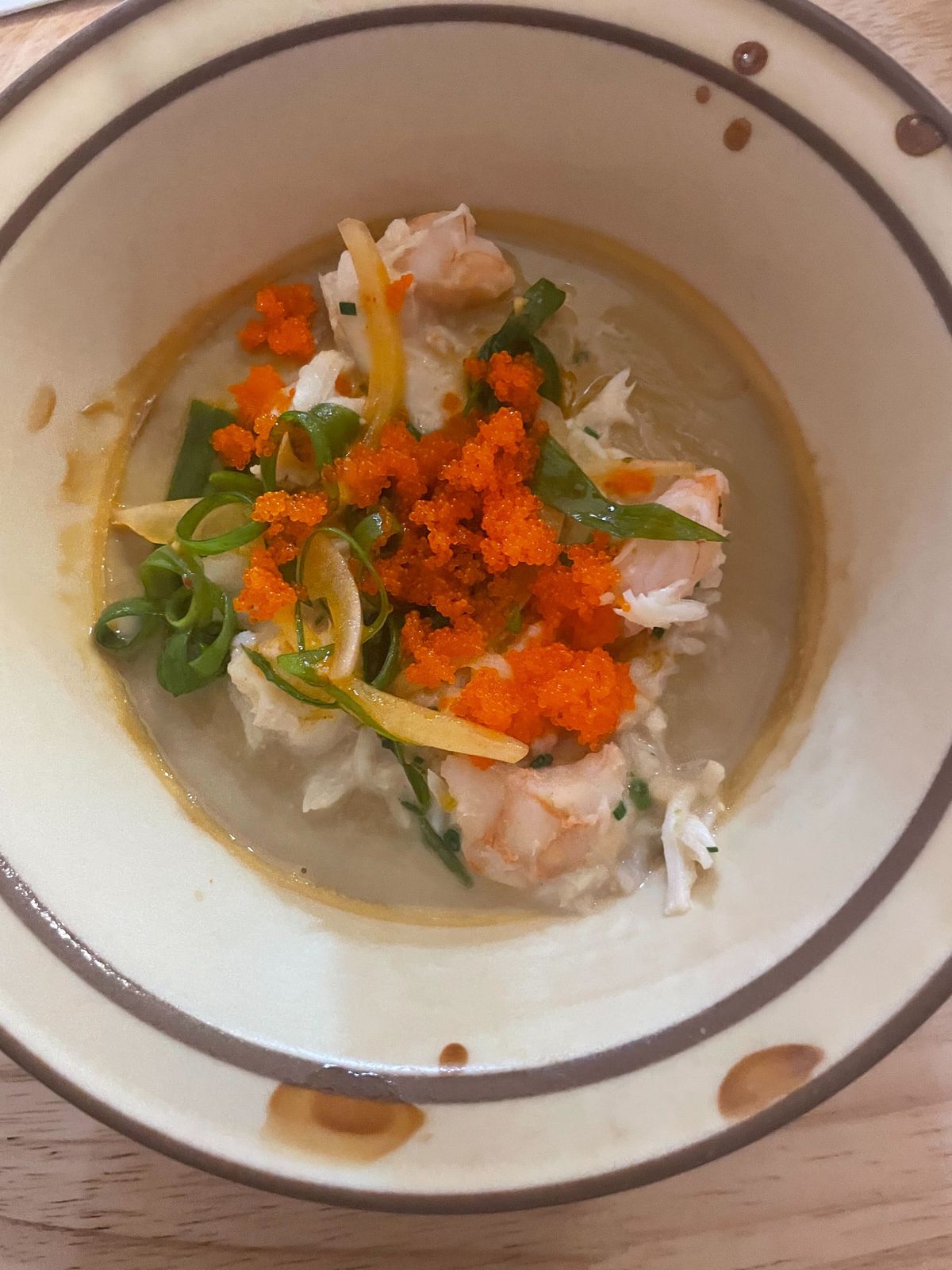 Pale bowl filled with savory custard and topped with crab, tobiko, and scallions