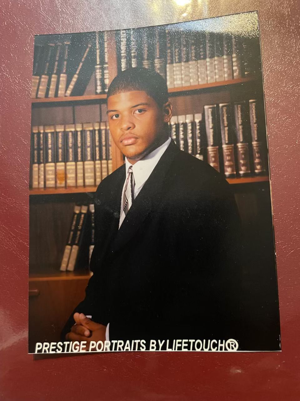 A high school image of young Keith Hyche posing in front of a bookcase.